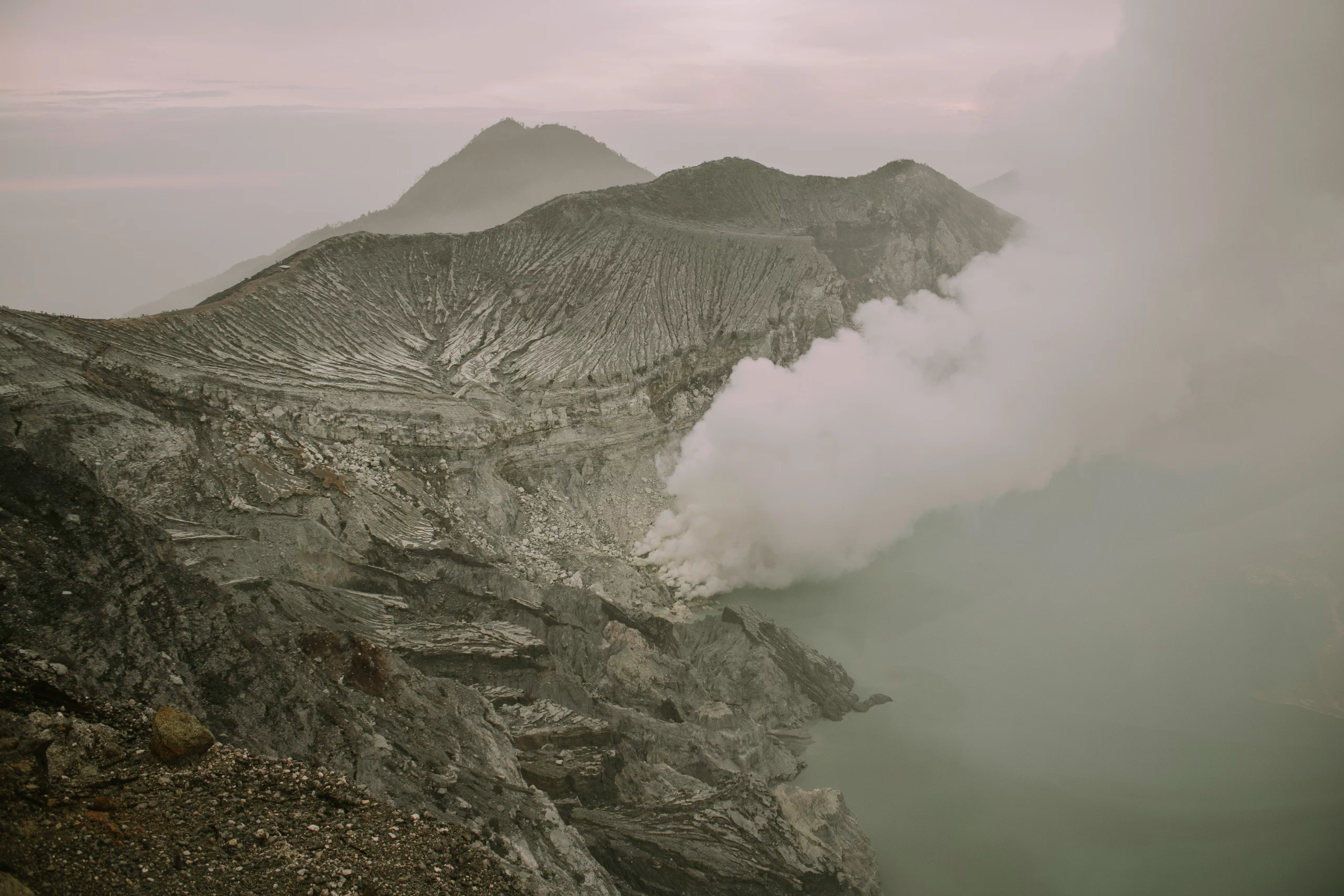Voyage entre femmes en Indonésie : cratère de volcan fumant avec parois abruptes et nuages de soufre – Salma Travel