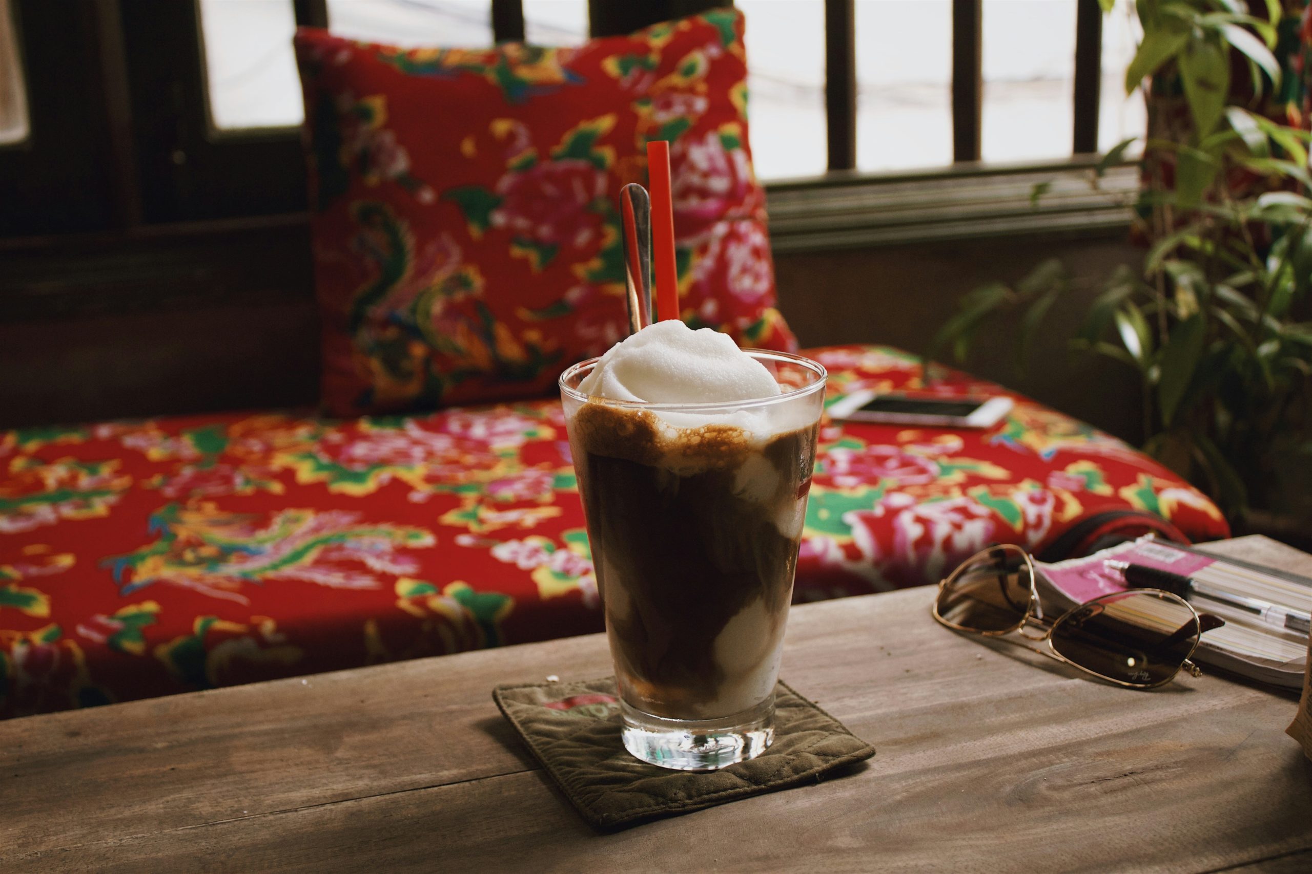 Voyage entre femmes au Vietnam : café vietnamien glacé avec mousse servi sur une table en bois – Salma Travel