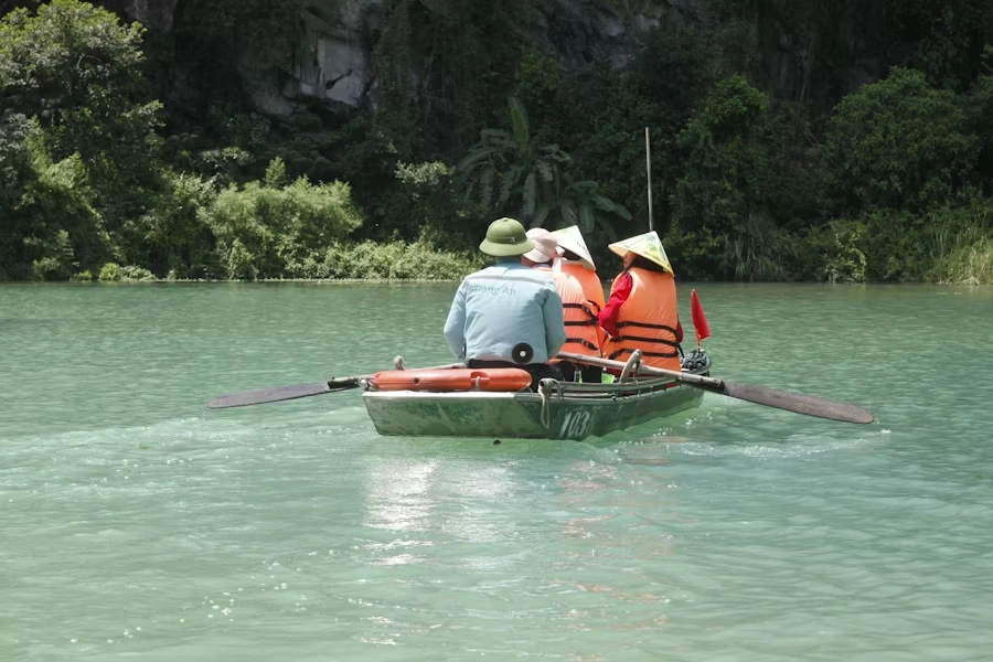 Voyage entre femmes au Vietnam : balade en kayak dans la baie d’Ha Long, eaux vert émeraude et participants avec chapeaux coniques – Salma Travel