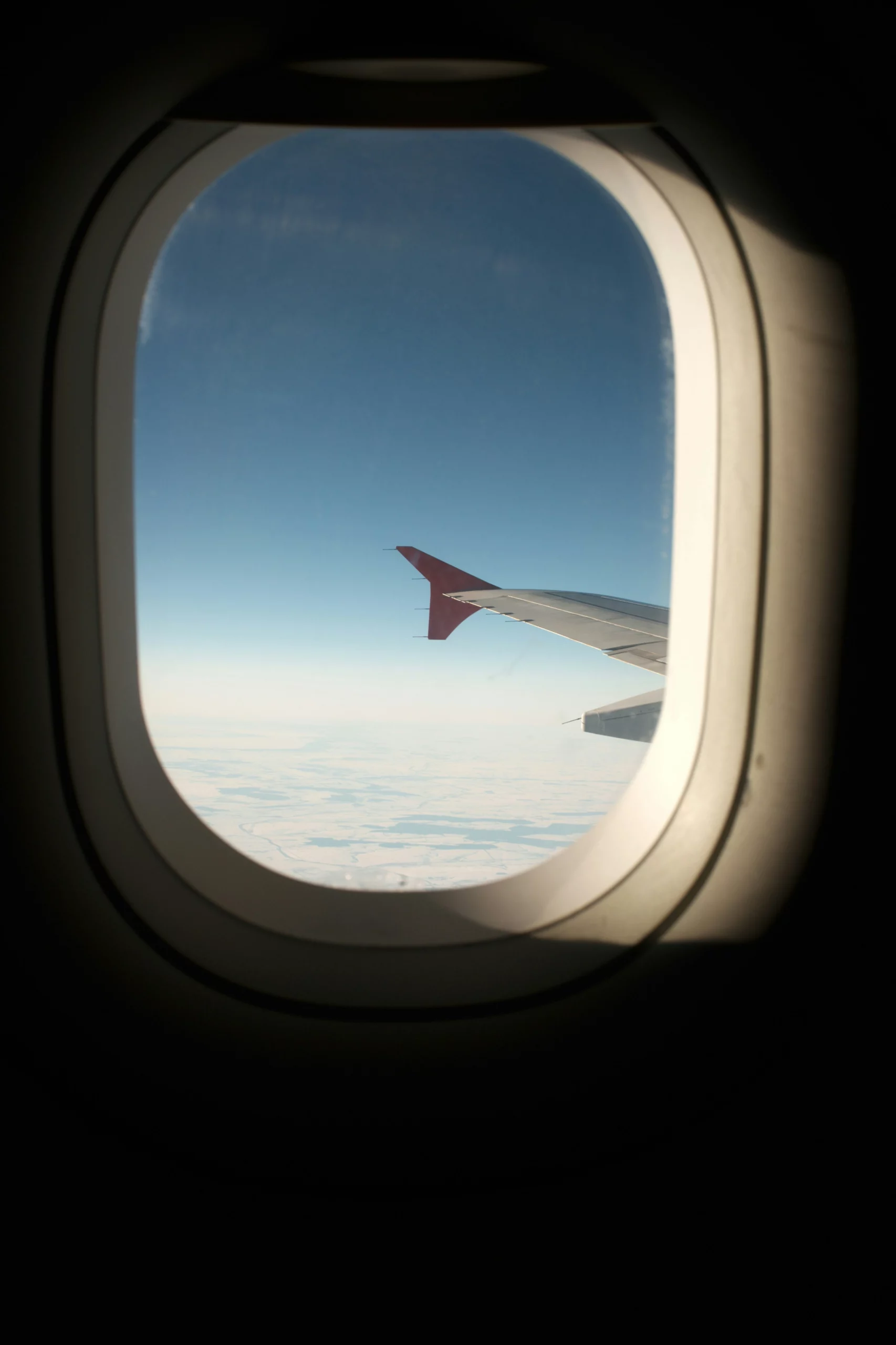 Voyage entre femmes au Maroc : vue d’un hublot d’avion avec aile au-dessus des nuages – Salma Travel